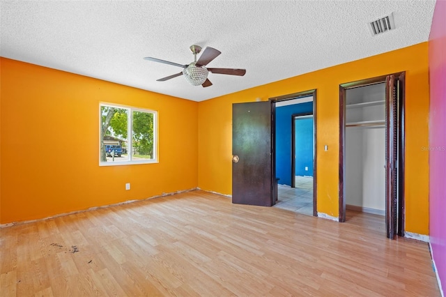 2302 16th St W, Palmetto, FL 34221 - unfurnished bedroom with wood finished floors, a textured ceiling, and ceiling fan