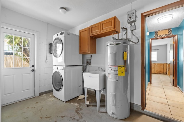 2302 16th St W, Palmetto, FL 34221 - laundry area featuring water heater, estacked washer and dryer, cabinet space, and a textured ceiling