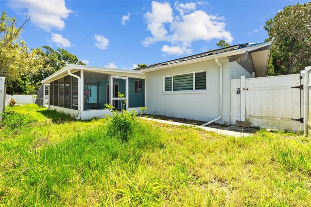 2302 16th St W, Palmetto, FL 34221 - back of house with a sunroom, a gate, and stucco siding