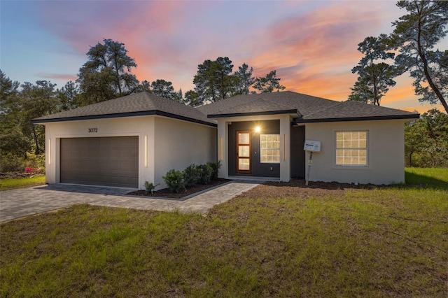 3072 SW 168th Loop, Ocala, FL 34473 - view of front of property featuring a garage, stucco siding, driveway, a front yard, and roof with shingles