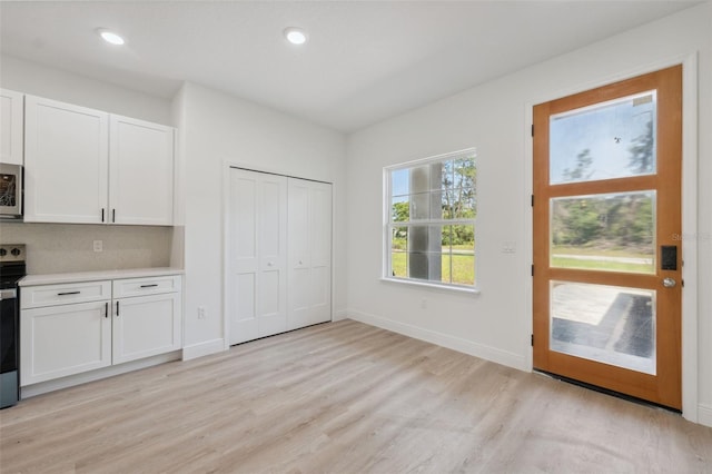 3072 SW 168th Loop, Ocala, FL 34473 - kitchen featuring white cabinets, stainless steel appliances, light wood-style flooring, light countertops, and baseboards