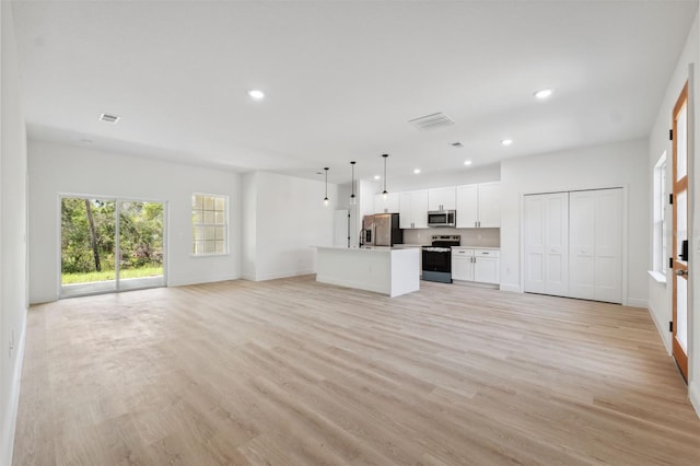 3072 SW 168th Loop, Ocala, FL 34473 - unfurnished living room featuring recessed lighting, light wood-style floors, and baseboards