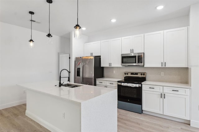 3072 SW 168th Loop, Ocala, FL 34473 - kitchen with appliances with stainless steel finishes, a sink, light wood-style floors, white cabinetry, and a kitchen island with sink