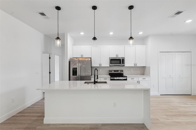 3072 SW 168th Loop, Ocala, FL 34473 - kitchen with stainless steel appliances, a sink, white cabinets, an island with sink, and recessed lighting