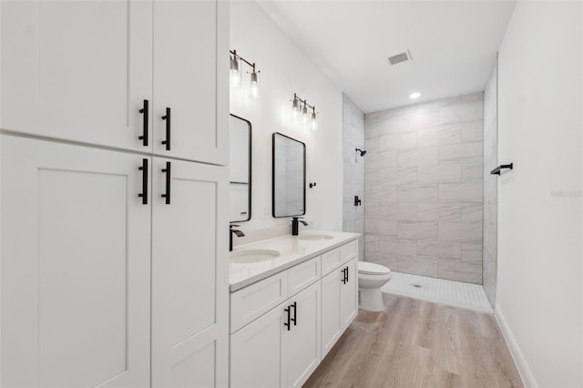 3072 SW 168th Loop, Ocala, FL 34473 - full bath with tiled shower, wood finished floors, toilet, double vanity, and recessed lighting