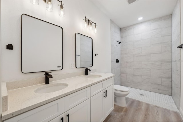 3072 SW 168th Loop, Ocala, FL 34473 - full bathroom featuring toilet, a tile shower, double vanity, wood finished floors, and recessed lighting