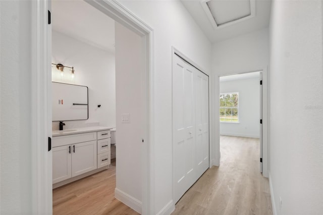 3072 SW 168th Loop, Ocala, FL 34473 - hall featuring light wood-type flooring, a sink, attic access, and baseboards