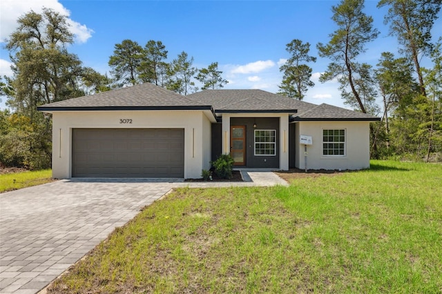 3072 SW 168th Loop, Ocala, FL 34473 - view of front facade featuring stucco siding, a garage, decorative driveway, a front yard, and roof with shingles