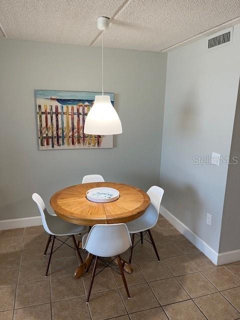 4453 S Atlantic Ave Unit 602, Ponce Inlet, FL 32127 - tiled dining room with a textured ceiling and baseboards