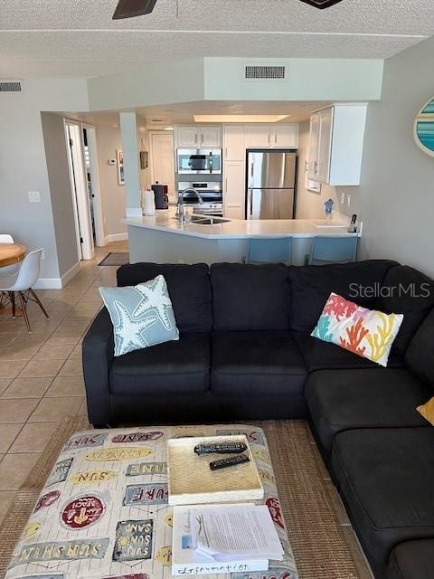 4453 S Atlantic Ave Unit 602, Ponce Inlet, FL 32127 - living area featuring a textured ceiling and light tile patterned floors