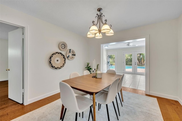dining area featuring french doors, wood finished floors, baseboards, and a chandelier