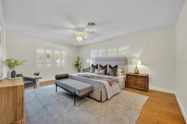 bedroom featuring baseboards, wood finished floors, and ceiling fan