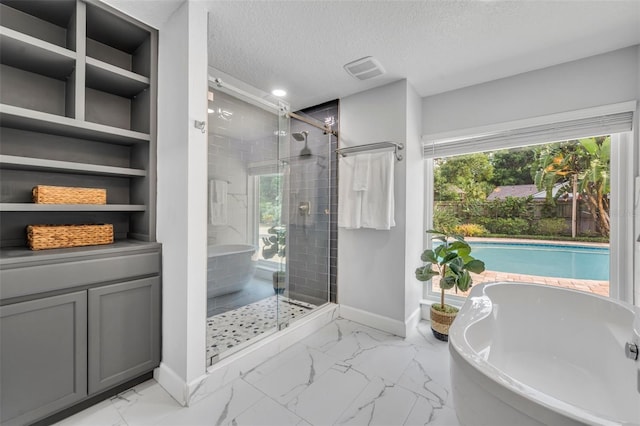 full bath featuring a stall shower, baseboards, a textured ceiling, marble look tiles, and a freestanding tub