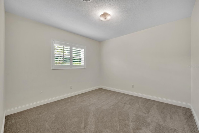 unfurnished room featuring carpet floors, baseboards, and a textured ceiling