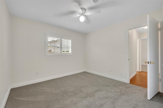 empty room featuring carpet flooring, a ceiling fan, and baseboards