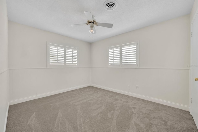 carpeted empty room featuring ceiling fan and baseboards