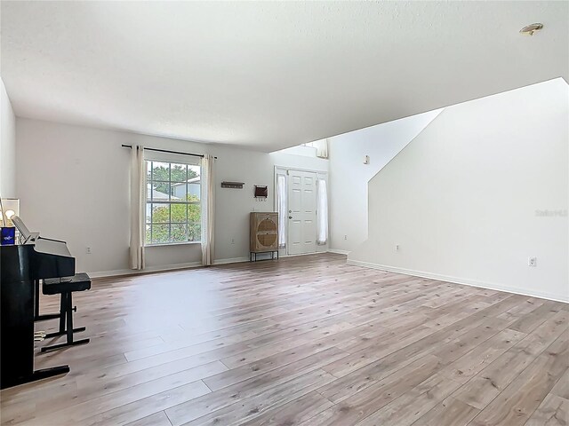 2384 Andrews Valley Dr, Kissimmee, FL 34758 - unfurnished living room featuring light wood-type flooring and baseboards