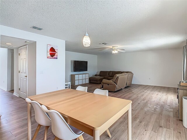 2384 Andrews Valley Dr, Kissimmee, FL 34758 - dining room with light wood-type flooring, ceiling fan, and a textured ceiling