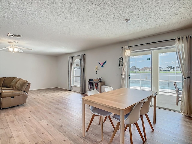 2384 Andrews Valley Dr, Kissimmee, FL 34758 - dining area featuring a textured ceiling, light wood-type flooring, and ceiling fan