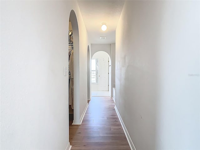 2384 Andrews Valley Dr, Kissimmee, FL 34758 - corridor featuring arched walkways, wood finished floors, and baseboards