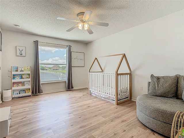 2384 Andrews Valley Dr, Kissimmee, FL 34758 - sitting room with a textured ceiling, ceiling fan, light wood-style flooring, and baseboards