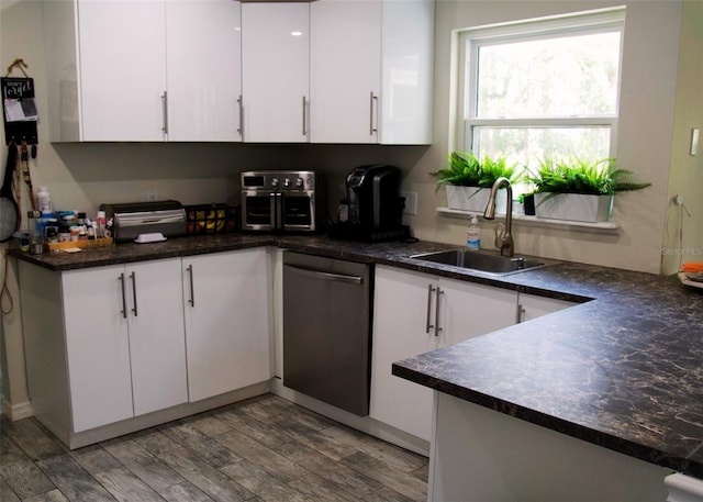 548 Glen Haven Dr, Deltona, FL 32738 - kitchen with stainless steel dishwasher, a sink, white cabinetry, and dark countertops
