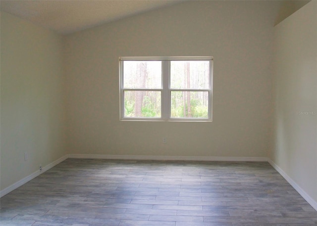 548 Glen Haven Dr, Deltona, FL 32738 - spare room with vaulted ceiling, wood finished floors, and baseboards