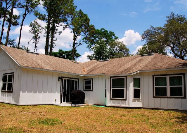 548 Glen Haven Dr, Deltona, FL 32738 - rear view of house featuring roof with shingles, a lawn, and board and batten siding