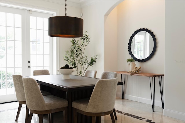 1010 Terrace Blvd, Orlando, FL 32803 - dining space featuring baseboards, inlaid floor details, arched walkways, french doors, and crown molding