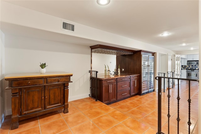 1010 Terrace Blvd, Orlando, FL 32803 - indoor bar with stainless steel microwave, range, light tile patterned floors, baseboards, and recessed lighting