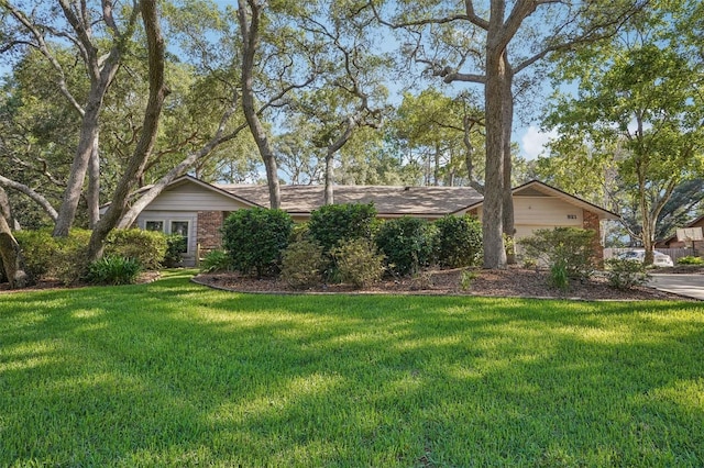 921 Torchwood Dr, Deland, FL 32724 - view of front of property with a front yard, brick siding, an attached garage, and concrete driveway