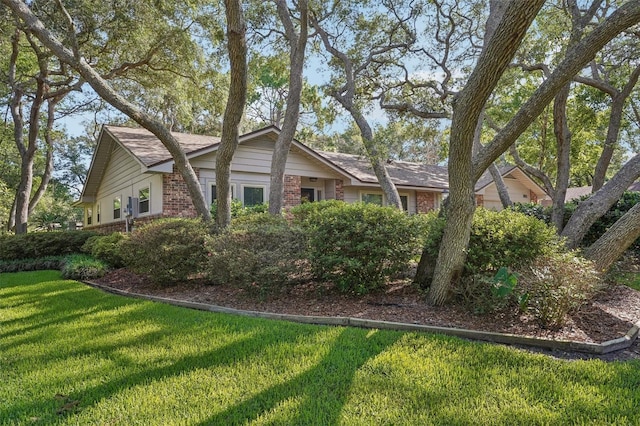 921 Torchwood Dr, Deland, FL 32724 - view of side of home with brick siding and a lawn