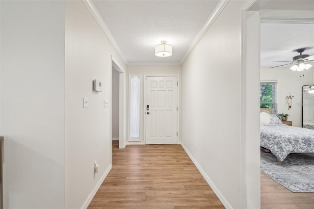 921 Torchwood Dr, Deland, FL 32724 - foyer featuring light wood-style flooring, ornamental molding, ceiling fan, baseboards, and a textured ceiling
