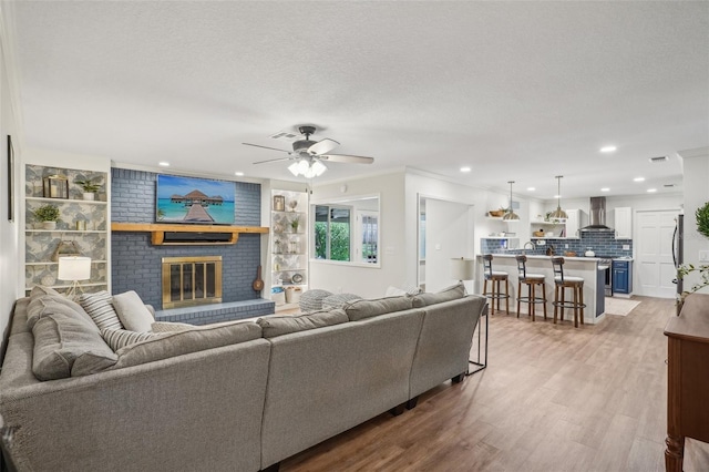 921 Torchwood Dr, Deland, FL 32724 - living area with light wood-style floors, a ceiling fan, a fireplace, recessed lighting, and crown molding