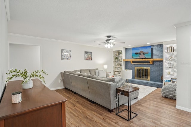 921 Torchwood Dr, Deland, FL 32724 - living room with a ceiling fan, wood finished floors, baseboards, crown molding, and a fireplace