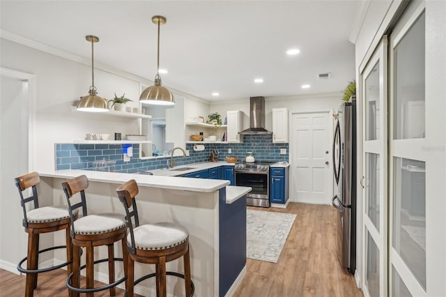 921 Torchwood Dr, Deland, FL 32724 - kitchen with blue cabinetry, appliances with stainless steel finishes, wall chimney range hood, open shelves, and a sink