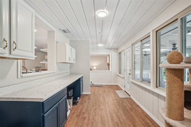 921 Torchwood Dr, Deland, FL 32724 - kitchen featuring blue cabinets, light wood-type flooring, white cabinetry, and baseboards