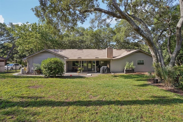 921 Torchwood Dr, Deland, FL 32724 - back of house with a chimney, a lawn, and a patio area