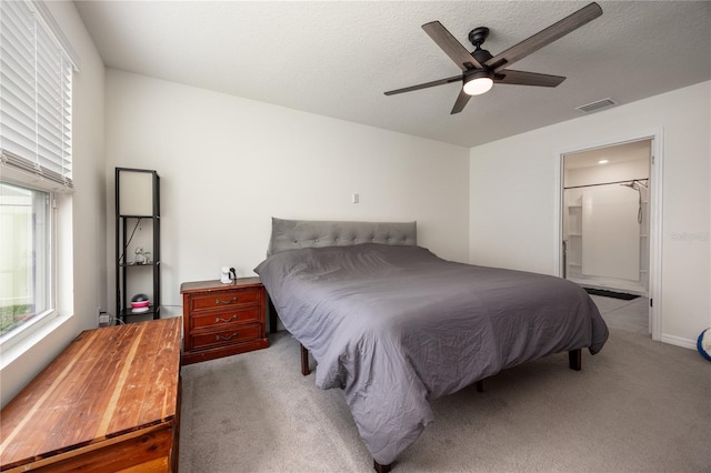 carpeted bedroom with a ceiling fan and a textured ceiling