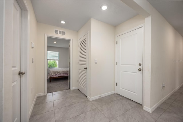 hall with light tile patterned floors, baseboards, and recessed lighting