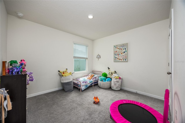 carpeted bedroom featuring baseboards and a textured ceiling