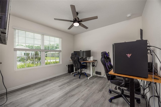 office with ceiling fan, wood finished floors, baseboards, and a textured ceiling