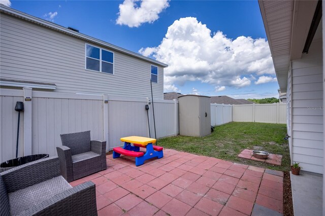 view of patio featuring a fenced backyard and a storage unit