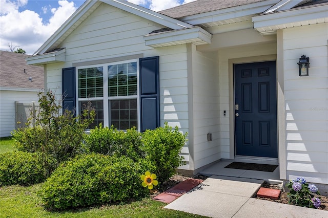 doorway to property with roof with shingles