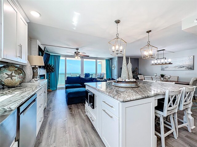 14146 Gulf Blvd Unit 3A, Madeira Beach, FL 33708 - kitchen featuring open floor plan, light wood-style flooring, dishwasher, a ceiling fan, and a kitchen island