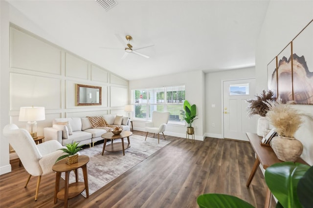 living area with a ceiling fan, plenty of natural light, vaulted ceiling, wood finished floors, and baseboards