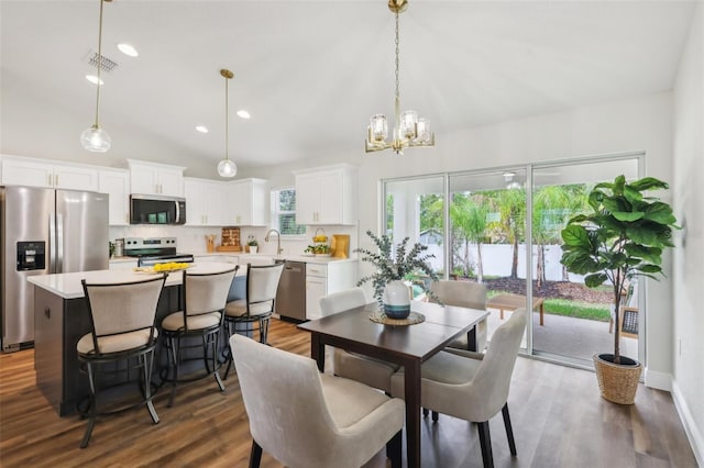 dining space featuring a chandelier, recessed lighting, dark wood finished floors, and lofted ceiling