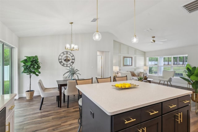kitchen featuring ceiling fan, healthy amount of natural light, light countertops, vaulted ceiling, and dark wood finished floors