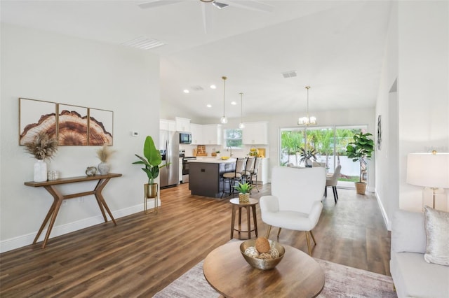living area featuring wood finished floors, a ceiling fan, vaulted ceiling, recessed lighting, and baseboards