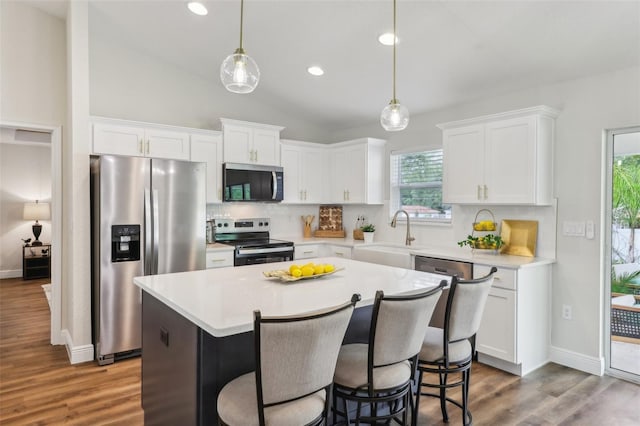 kitchen with appliances with stainless steel finishes, a sink, decorative backsplash, white cabinets, and recessed lighting